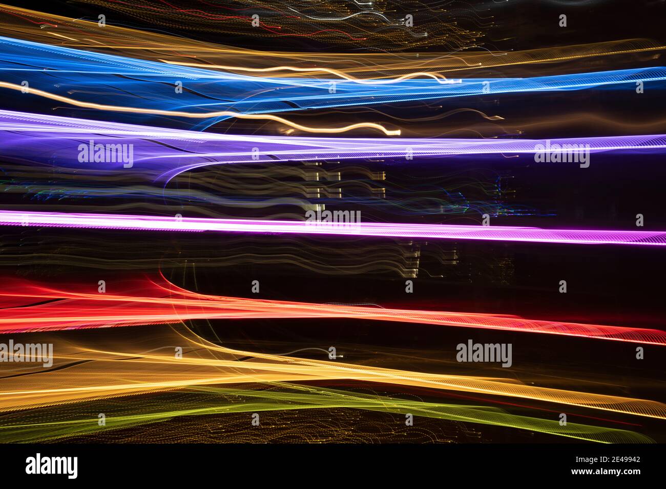 Abstraktes Farbspektrum in Gittermusterformen übereinander geschichtet, erstellt von LED-Leuchten, die nachts im Freien fotografiert werden. Stockfoto