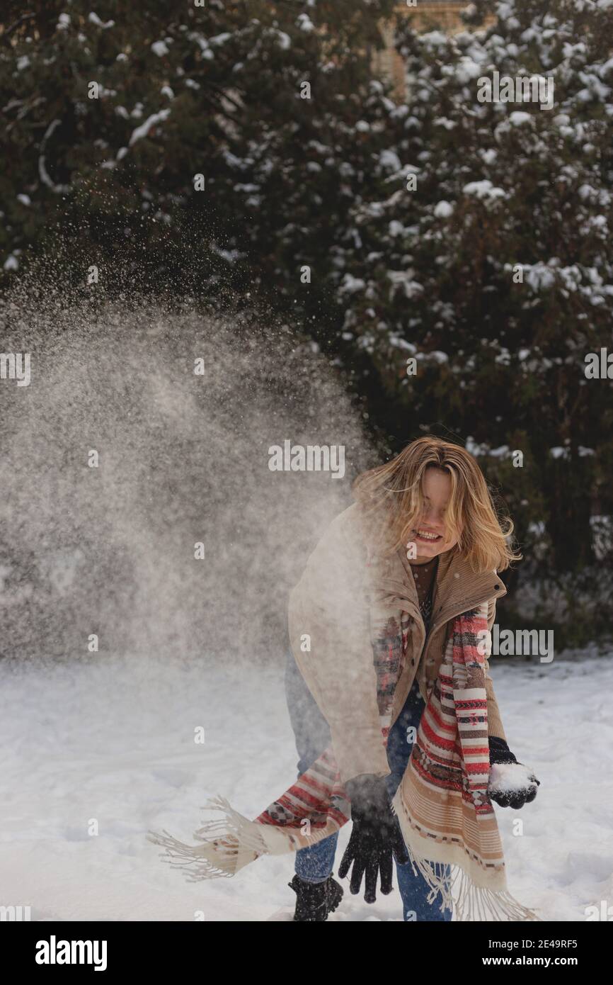 Blonde kaukasische Mädchen wirft Schnee genießen Winter Stockfoto