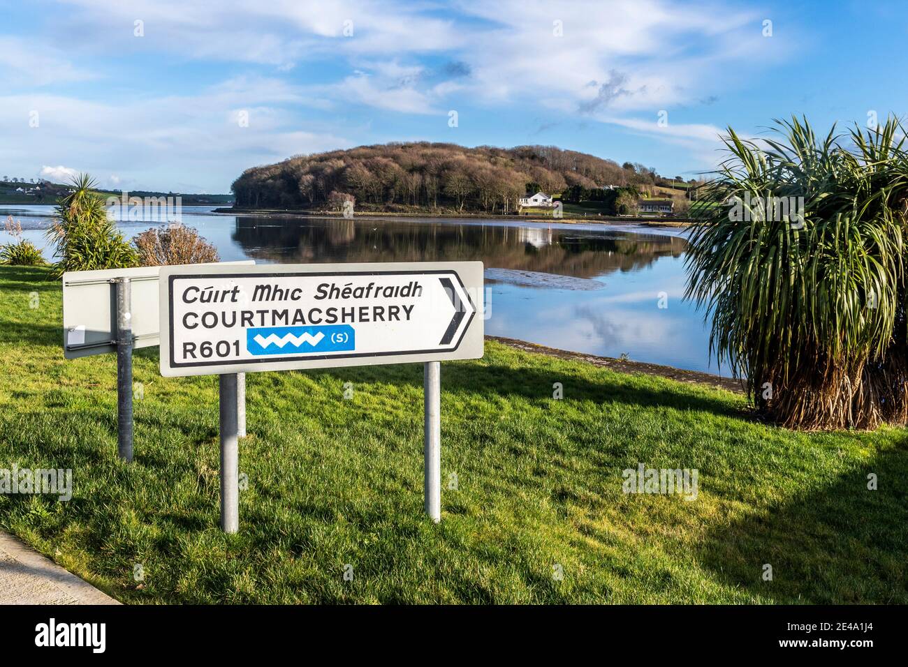 Irish Road Schild in Timoleague zeigt den Weg nach Courtmacsherry, West Cork, Irland mit dem Wild Atlantic Way Logo. Stockfoto