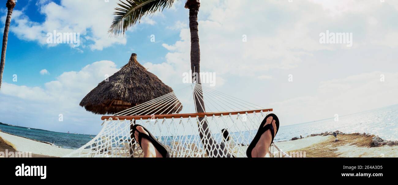 Person, die in der Hängematte am Strand, Key Largo, Florida Keys, Florida, USA ruht Stockfoto