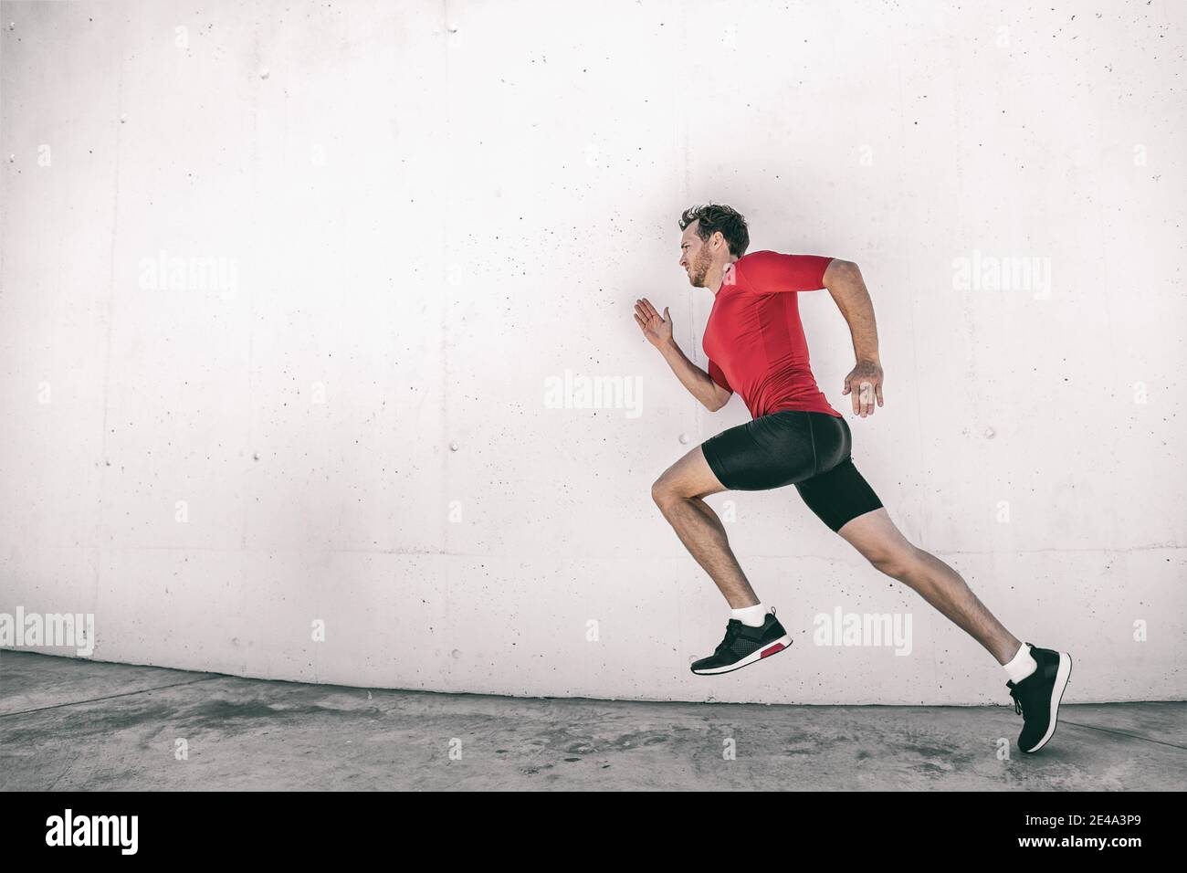 Laufmann fit Athlet männlichen Läufer trainieren draußen tun Stadt Straße laufen Sprinten entlang Turnhalle Wand. Sprinter geht schnell leben aktiven Lebensstil Stockfoto