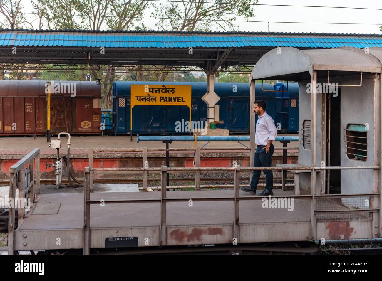 Wache eines Güterzuges macht einen Spaziergang vor seiner Kabine, als sein Zug wartet auf Freigabe am Panvel Bahnhof, Navi Mumbai, Maharashtra, Indien Stockfoto