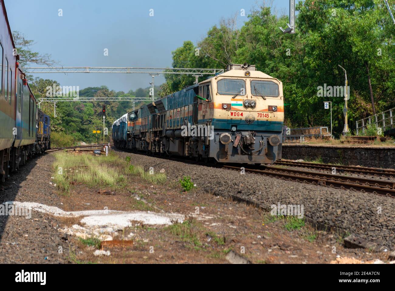 Güterzug Kreuzung 02413 Madgaon - Delhi Hazrat Nizamuddin Rajdhani Special an schönen malerischen Pernem Bahnhof auf Konkan Railway. Stockfoto