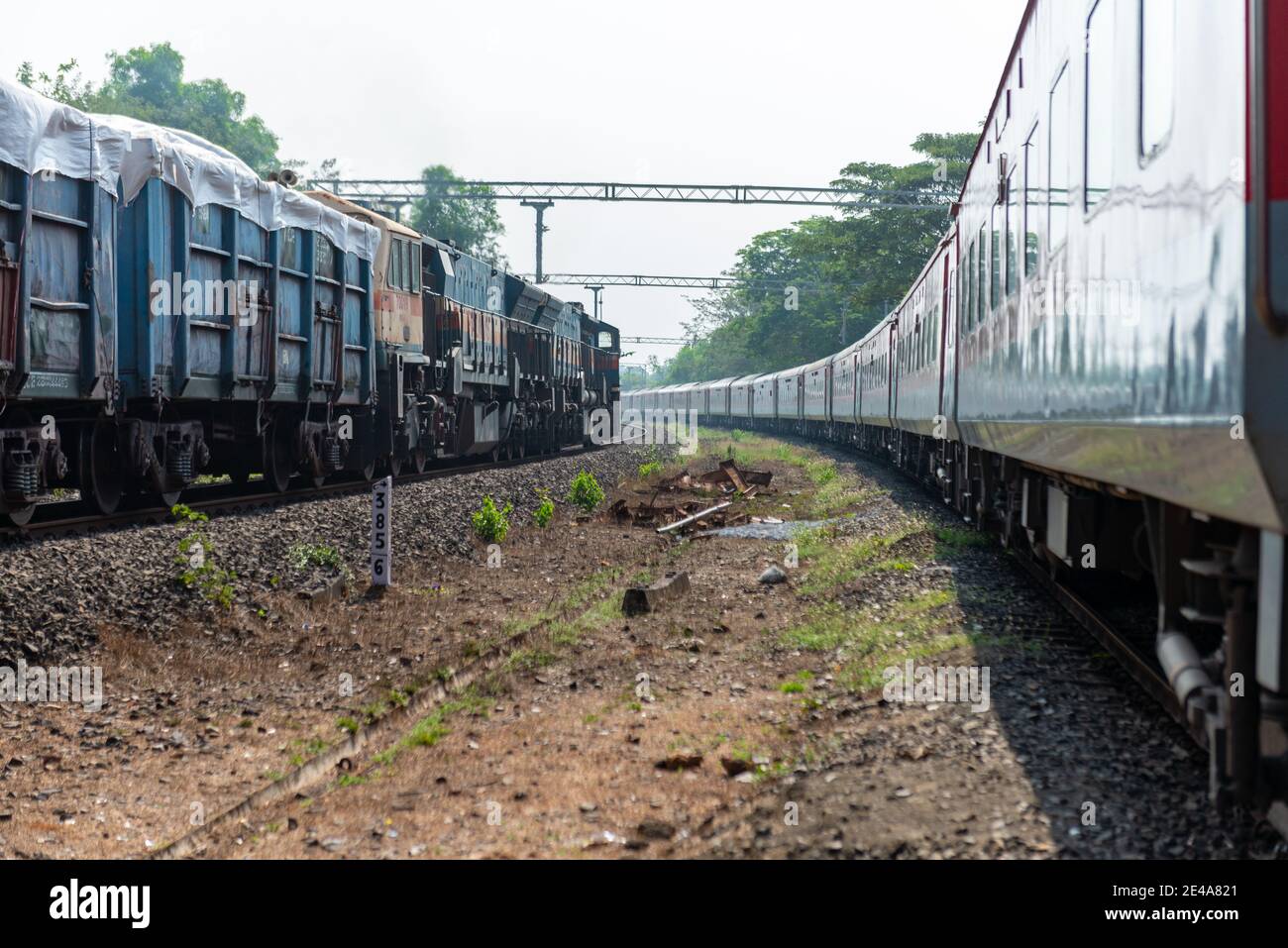 Güterzug Kreuzung 02413 Madgaon - Delhi Hazrat Nizamuddin Rajdhani Special an schönen malerischen Pernem Bahnhof auf Konkan Railway. Stockfoto