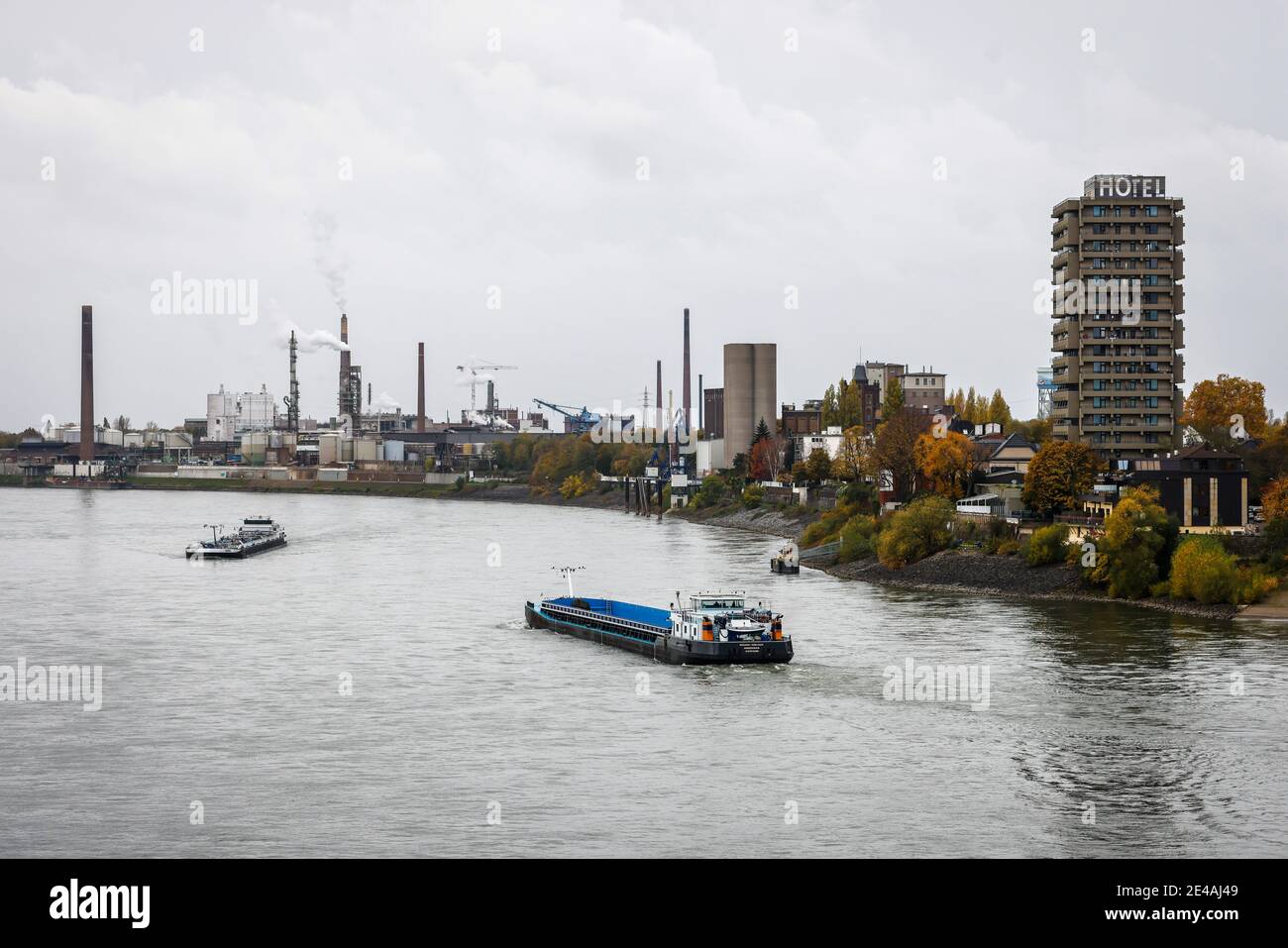 Duisburg, Ruhrgebiet, Nordrhein-Westfalen, Deutschland - Industrielandschaft, Binnenschiffe fahren auf dem Rhein vorbei am Hotel Rheingarten und den Chemiewerken im Duisburger Hafen im Stadtteil Homberg. Stockfoto