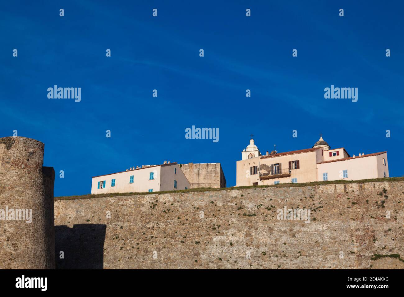 Befestigte Mauer mit Gebäuden im Hintergrund, Calvi, La Balagne, Haute-Corse, Korsika, Frankreich Stockfoto