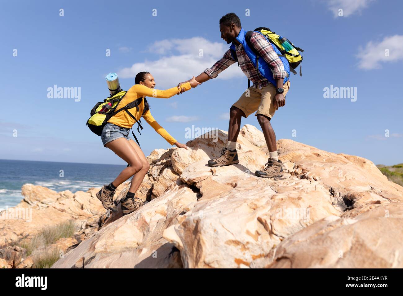 Fit afranamerikanischen Paar trägt Rucksäcke Wandern an der Küste Stockfoto