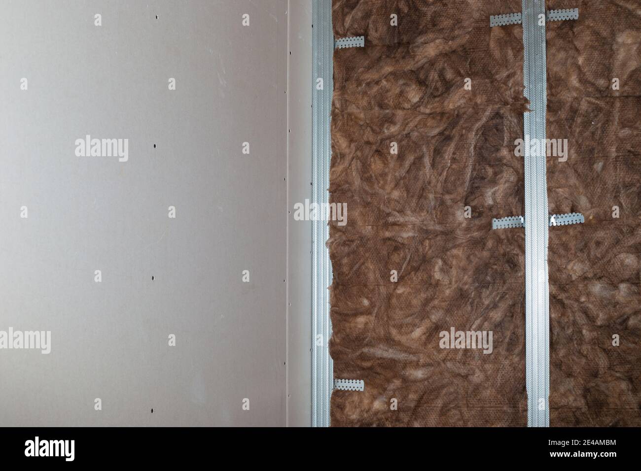 Isolierung und Schalldämmung der Wände mit Mineralwolle, vor der Verkleidung mit Gipskarton. Renovierung des Hauses. Stockfoto