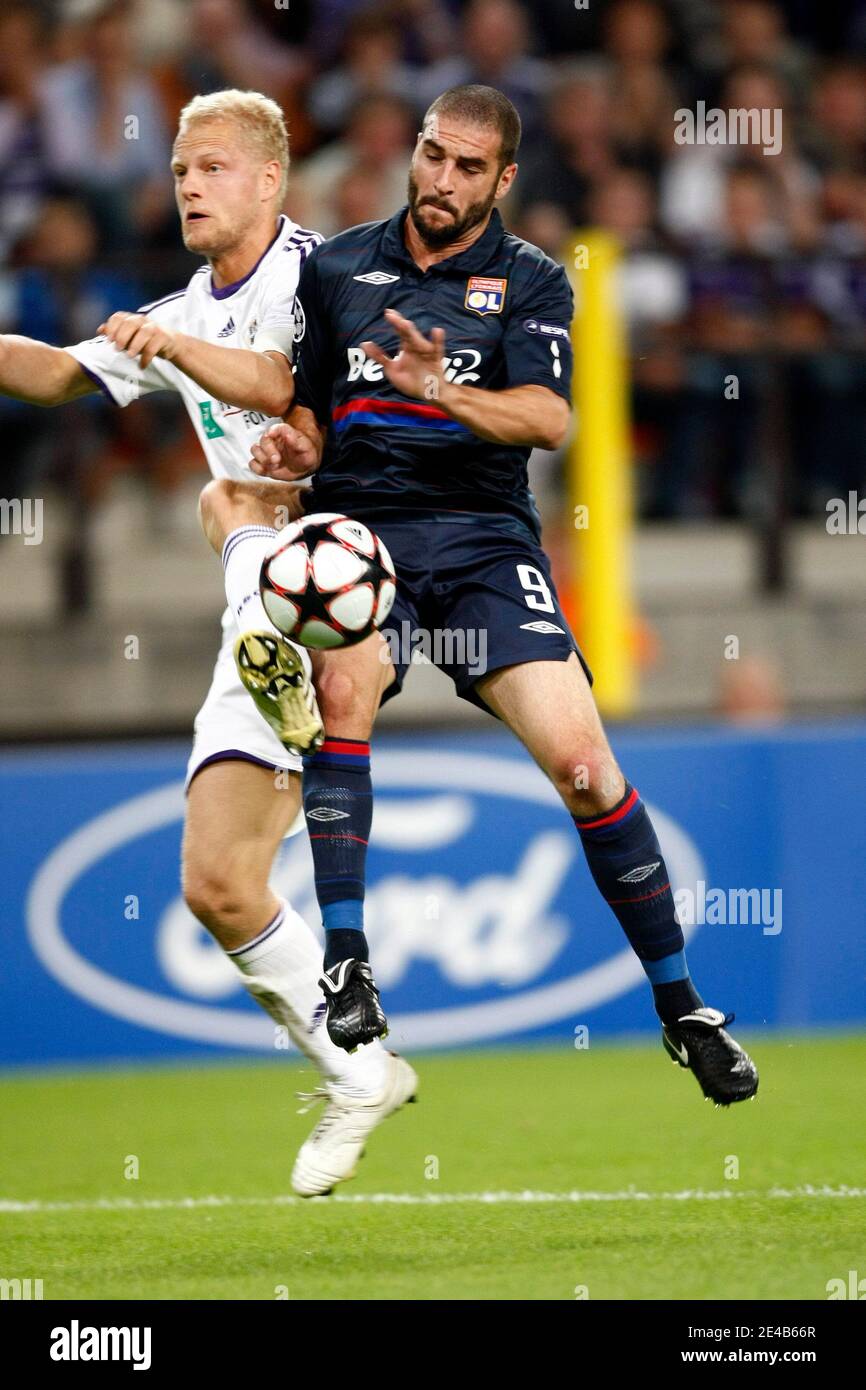 Lyons Lisandro (L) kämpft im Stadion Constant Vanden Stock um den Ball Anderlecht's Olivier Deschacht während des Champions-League-Play-off-Fußballspiels zwischen Olympique Lyonnais von Lyon (Frankreich) und Royal Sporting Club Anderlecht (Belgien) Stockfoto