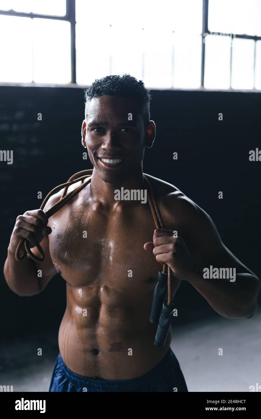 Porträt eines afroamerikanischen Mannes, der Seil über seine springen Schultern in leerem Stadtgebäude Stockfoto