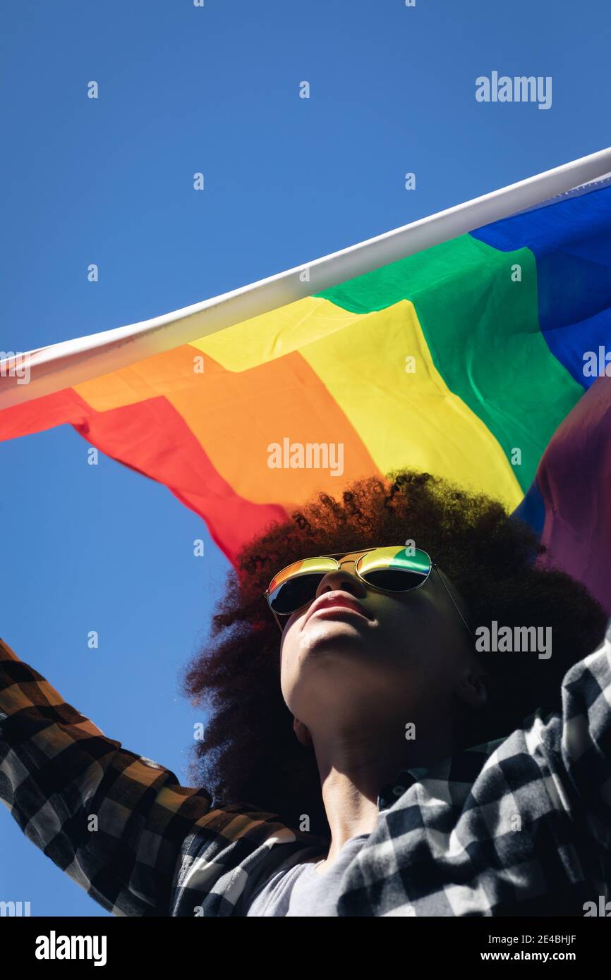 Gemischte Rasse Frau auf dem Dach stehend mit Regenbogenfahne Stockfoto