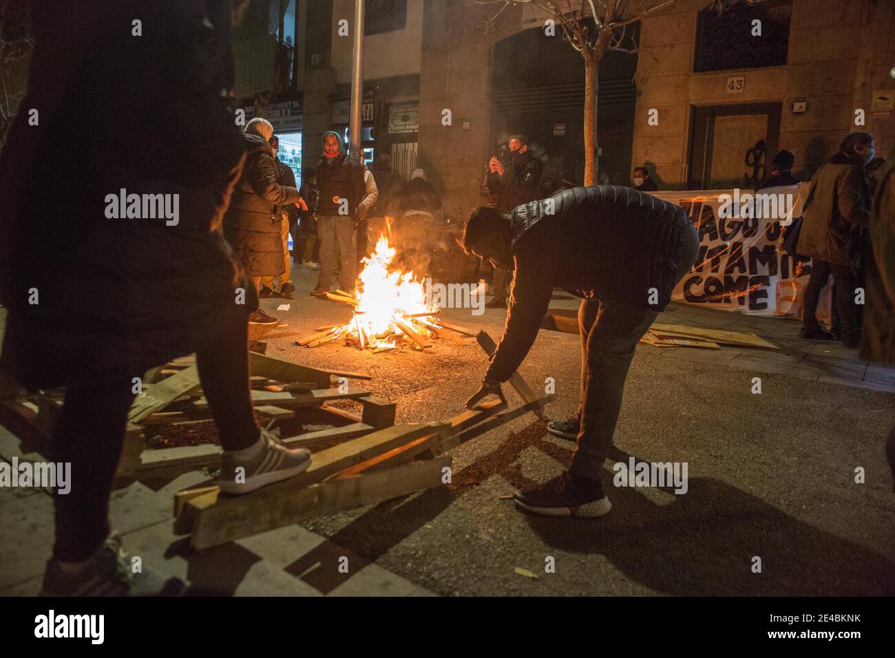 Barcelona, Katalonien, Spanien. Januar 2021. Demonstranten werden gesehen, wie sie Holz brechen, um das Feuer am Feuer zu halten.die Wohnungsunion des Viertels Raval in Barcelona hat eine Demonstration aufgerufen, um vom stadtrat Lösungen für ein Gebäude zu fordern, das ohne Installation ist, und eine Wohnungsalternative für alle Bewohner des Viertels, die unter der Macht leiden Und Wasserabfälle. Quelle: Thiago Prudencio/DAX/ZUMA Wire/Alamy Live News Stockfoto