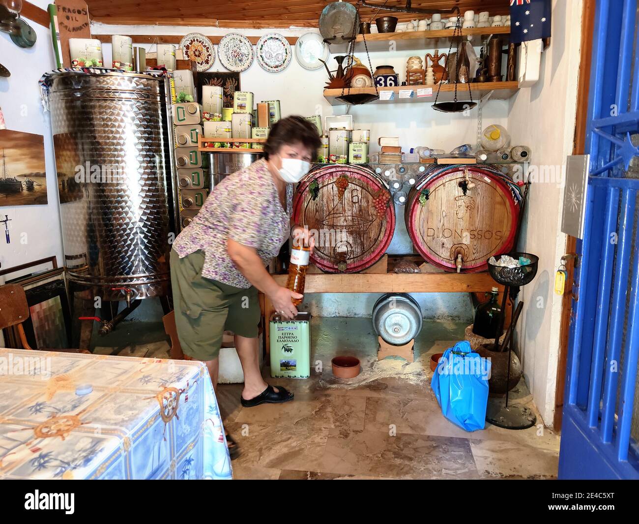 Typischer Verkauf von Wein aus dem Holzfass direkt vom Erzeuger, Landwirt mit Schutzmaske, Corona Times, Messenia, Peloponnes, Griechenland Stockfoto