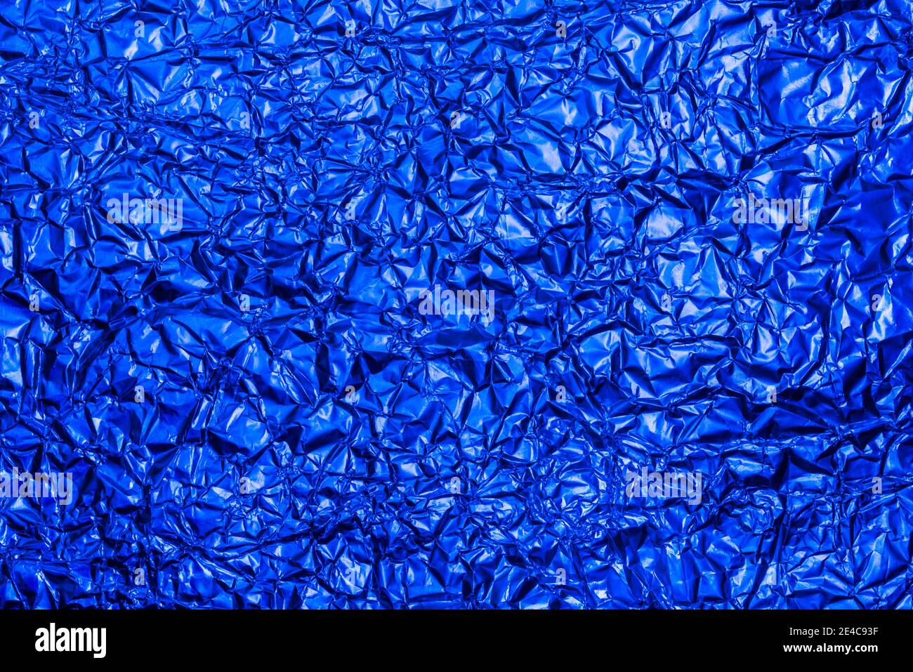 Heller blauer Folienhintergrund mit glänzend zerknitterter Oberfläche für Textur Hintergrund. Schillernde Oberfläche zerknittert Folie. Stockfoto