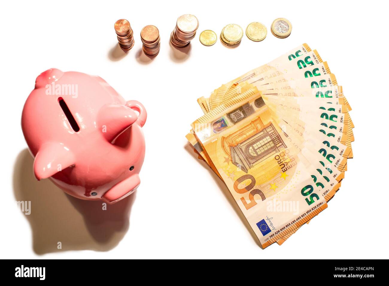 Isoliert mit weißem Hintergrund fünfzig Euro Banknote Geld und Stapel von Cent-Münzen. Sparschwein in Nahaufnahme. Finanzierungskonzept Stockfoto