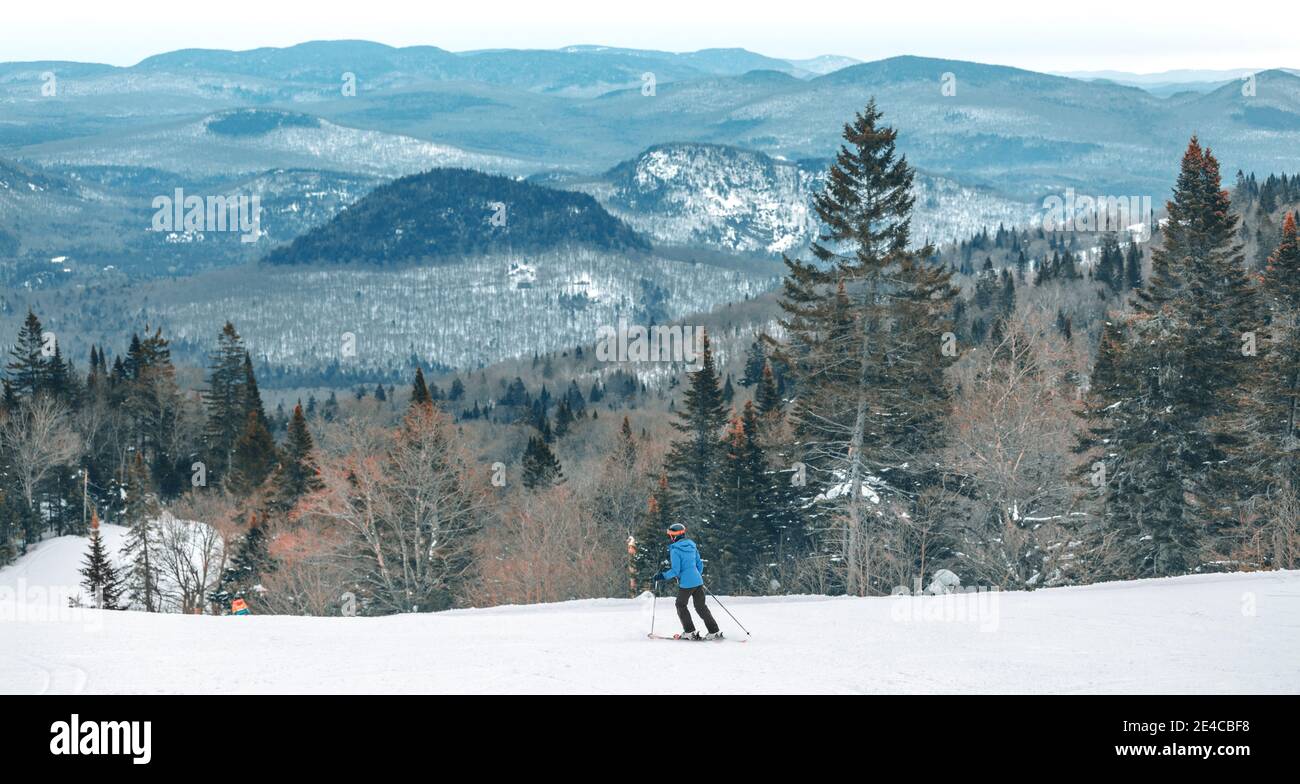 Skihang Blick auf Berggipfel Landschaft Frau Skifahren nach unten. Alpin Ski-Skifahrer Reiten weißen Pulverschnee Piste bei kaltem Wetter auf idyllische Wald Natur Stockfoto