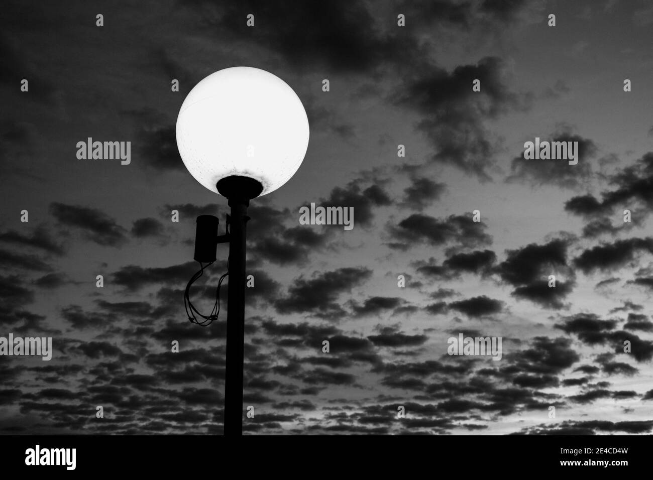 White Light Post zeigen mit einem schönen bewölkten Himmel Bei Sonnenuntergang [Schwarz-Weiß-Version] Stockfoto