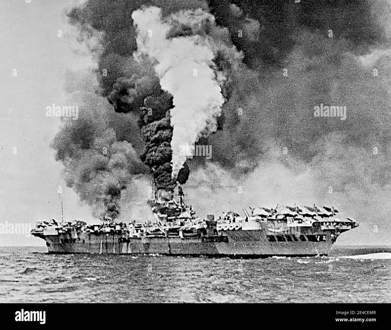 Der Flugzeugträger HMS Formidable (R67) in Brand, nachdem er von einer Kamikaze vor Sakishima Gnato getroffen wurde. Formidable wurde um 1130 Uhr getroffen, die Kamikaze machte eine massive Delle etwa 3 m lang, 0.6 m breit und tief in der gepanzerten Flugdeck. Ein großer Stahlsplitter spreizte durch das Hangardeck und den mittleren Kesselraum, wo er eine Dampfleitung zerbrach, und kam in einem Kraftstofftank zur Ruhe, was einen Großbrand im Flugzeugpark ausbrach. Acht Besatzungsmitglieder wurden getötet und 47 verletzt. Ein Vought Corsair und zehn Grumman Avengers wurden zerstört. Mai 1945 Stockfoto