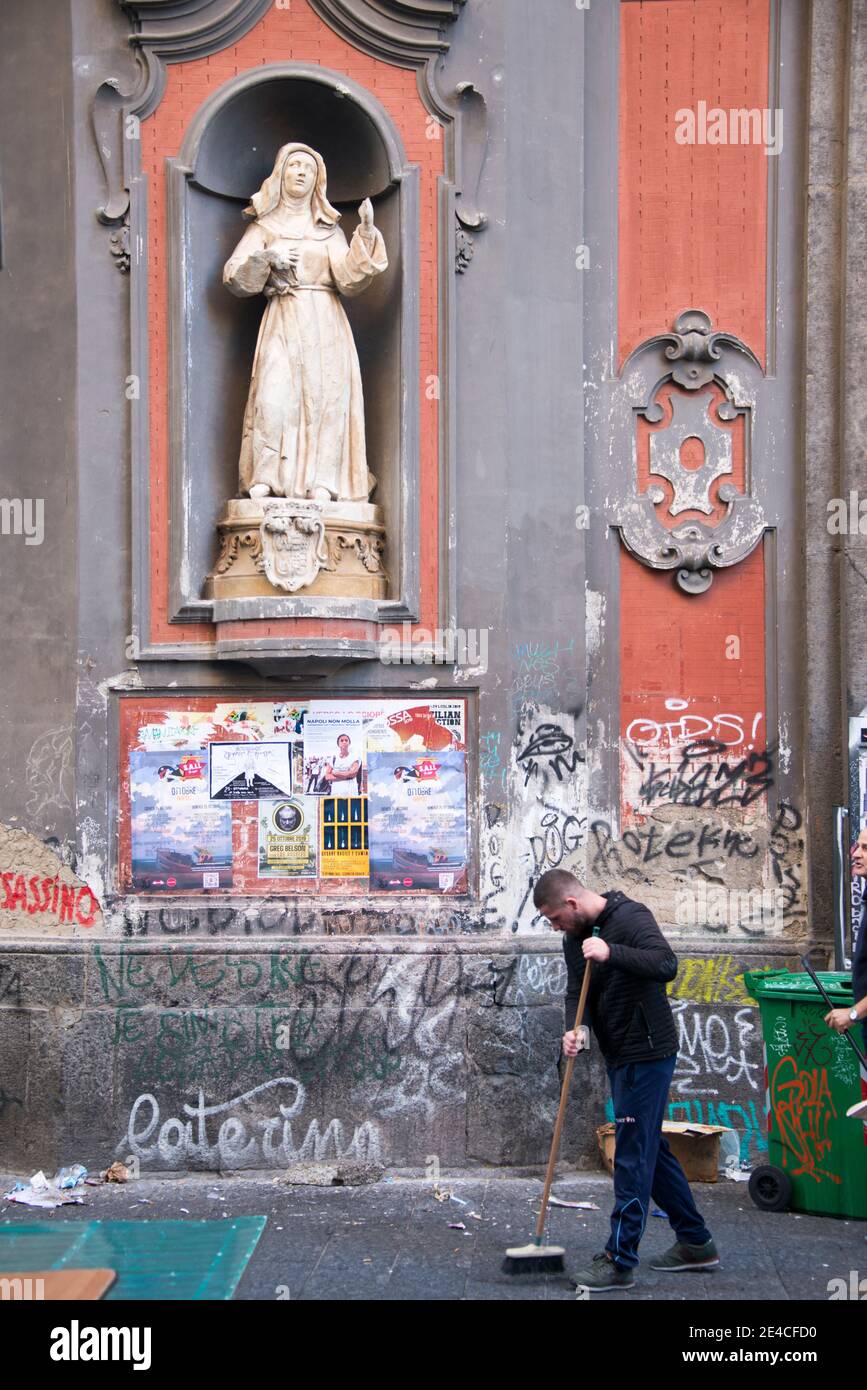 Neapel, Kirchenfassade mit Plakaten und Graffiti, Straßenkehrmaschinen im Vordergrund Stockfoto