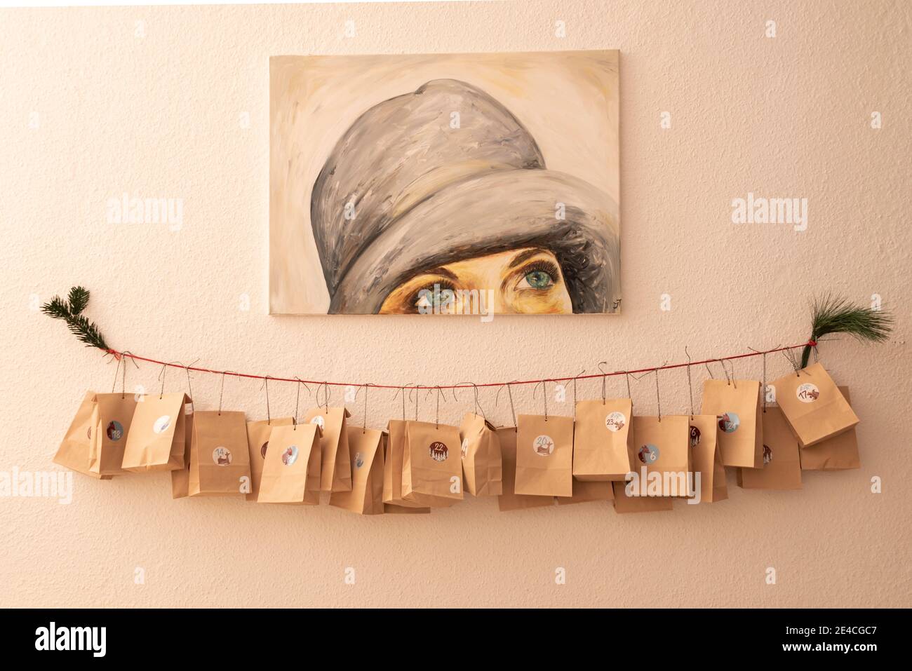 Adventskalender hängt an der Wand, Malerei Frau mit Hut Stockfoto