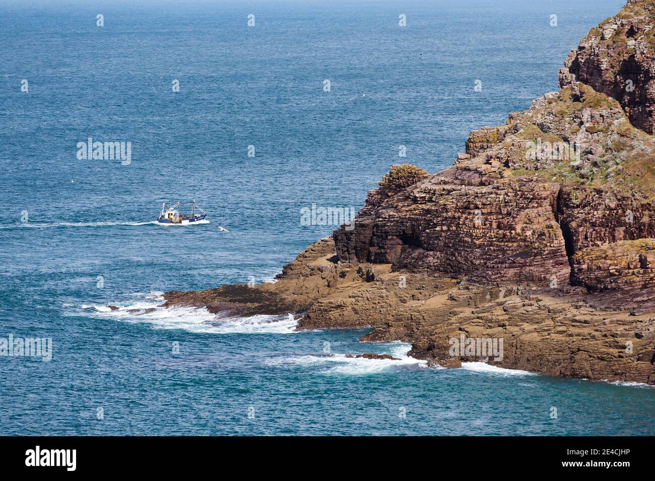 Ein Fischerboot fährt um die Klippen des Cap Frehel. Bretagne, Frankreich Stockfoto