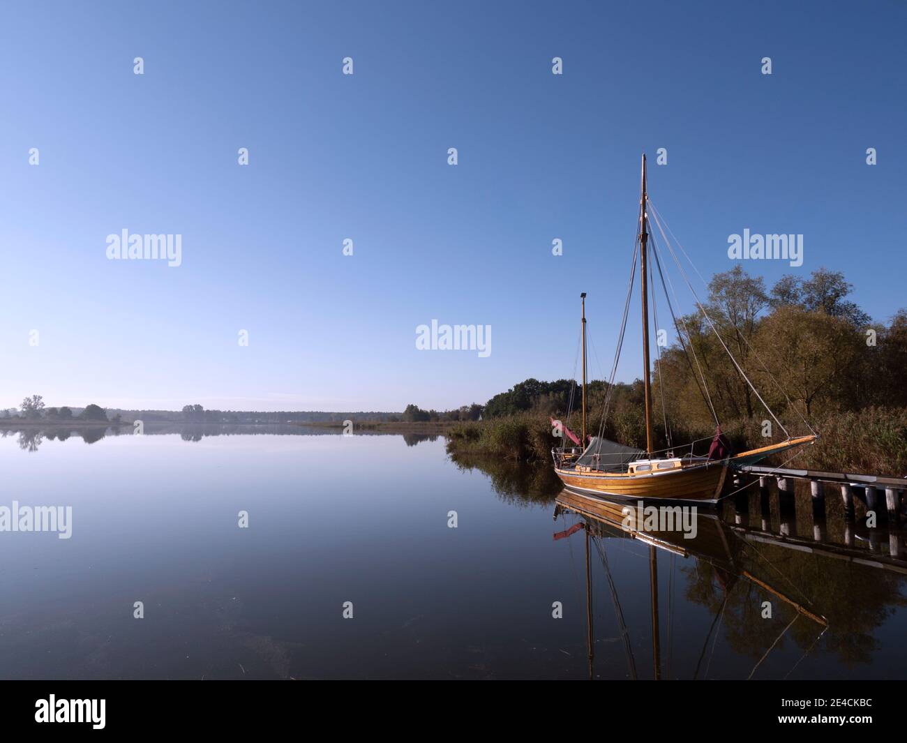 Am Morgen wird ein Zeesboot am Ufer beleuchtet Sonne und wird im Wasser reflektiert Stockfoto