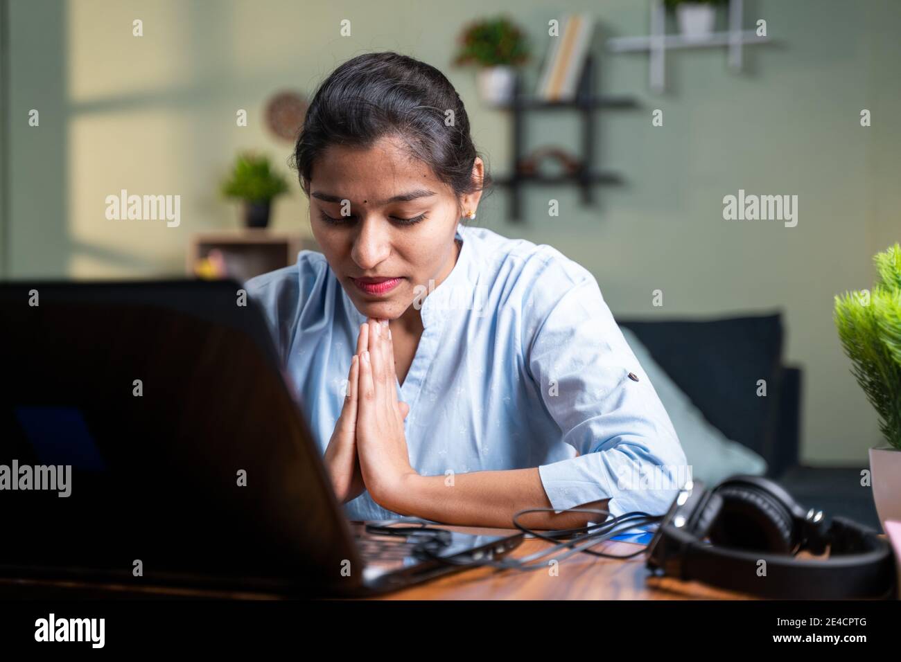 Junge Geschäftsfrau beten vor dem Laptop nach Abschluss der Online-Test oder Prüfung für Ergebnisse - Konzept des Glaubens, Dankbarkeit in gott Stockfoto