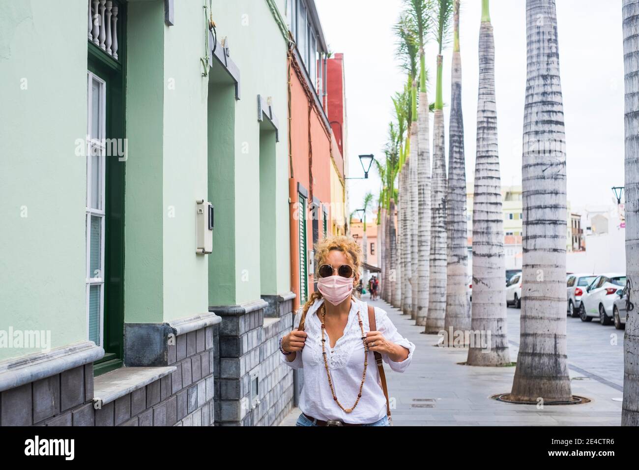 Erwachsene Frau tragen Schutzmaske gegen covid-19 Coronavirus Virus Notfall - Schützen Sie sich Menschen mit Anti-Virus-Zubehör - weiblich In der Stadt mit Telefon lesen Nachrichten über Gesundheit Stockfoto