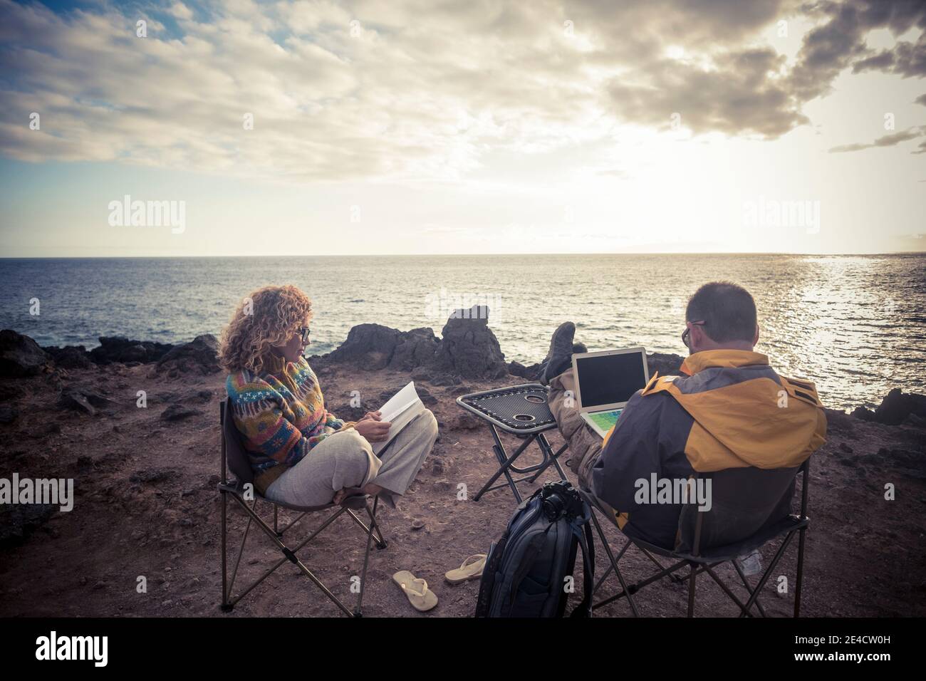 Ein erwachsenes Paar setzt sich mit Computer am Felsenstrand hin Und buchen Sie genießen Sie die Reise Abenteuer Urlaub und Smart Working Online-Konzept - Menschen und Outdoor-Lifestyle Stockfoto Ein erwachsenes Paar setzt sich mit Computer am Felsenstrand hin Und buchen Sie genießen Sie die Reise Abenteuer Urlaub und Smart Working Online-Konzept - Menschen und Outdoor-Lifestyle Stockfoto