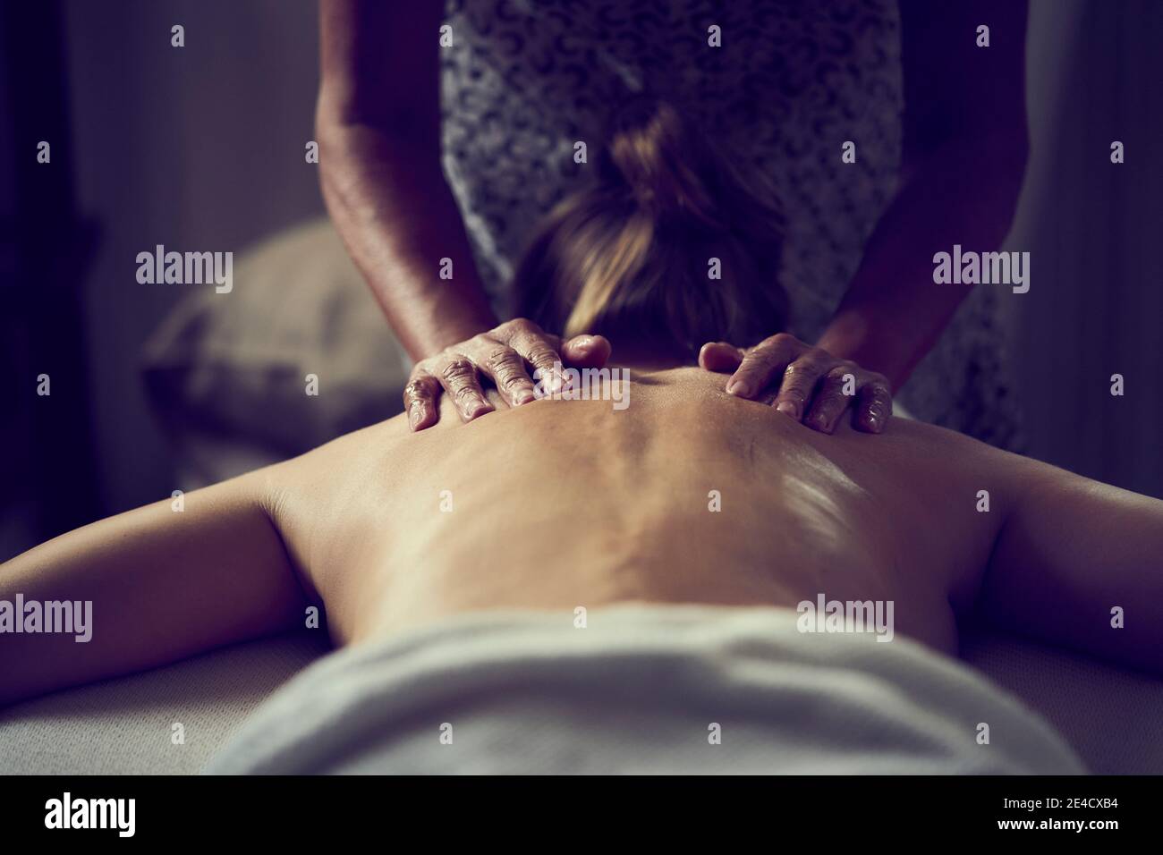 Eine Frau, die eine Ganzkörperölmassage von einem erhält Professionelle Masseuse Stockfoto