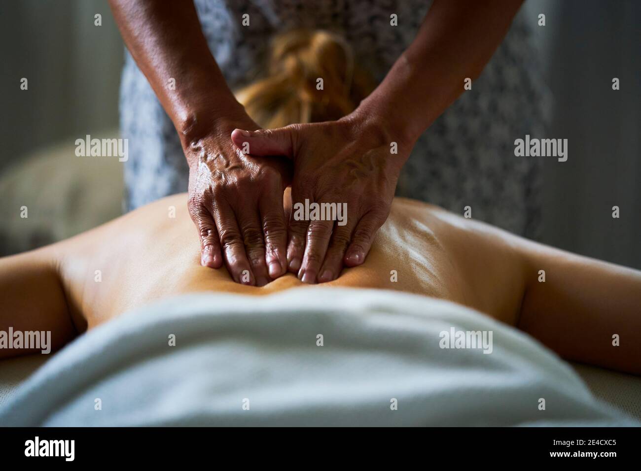 Eine professionelle Masseurin, die einer Dame eine Ölmassage gibt. Stockfoto