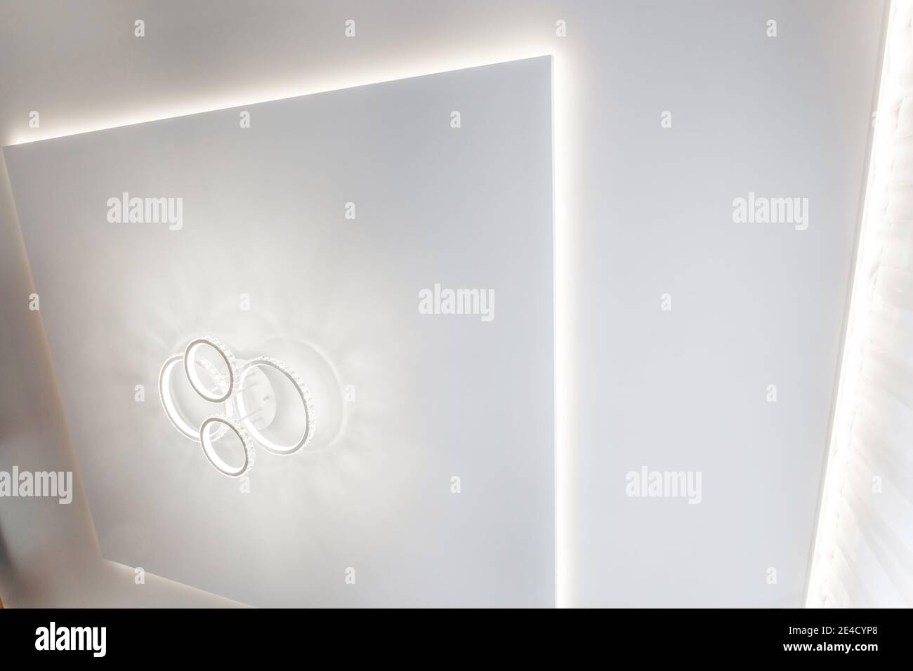 Abgehängte Decke mit Halogenstrahlern und Trockenmauerkonstruktion im leeren Raum in Wohnung oder Haus. Stretchdecke weiß und komplex. Stockfoto