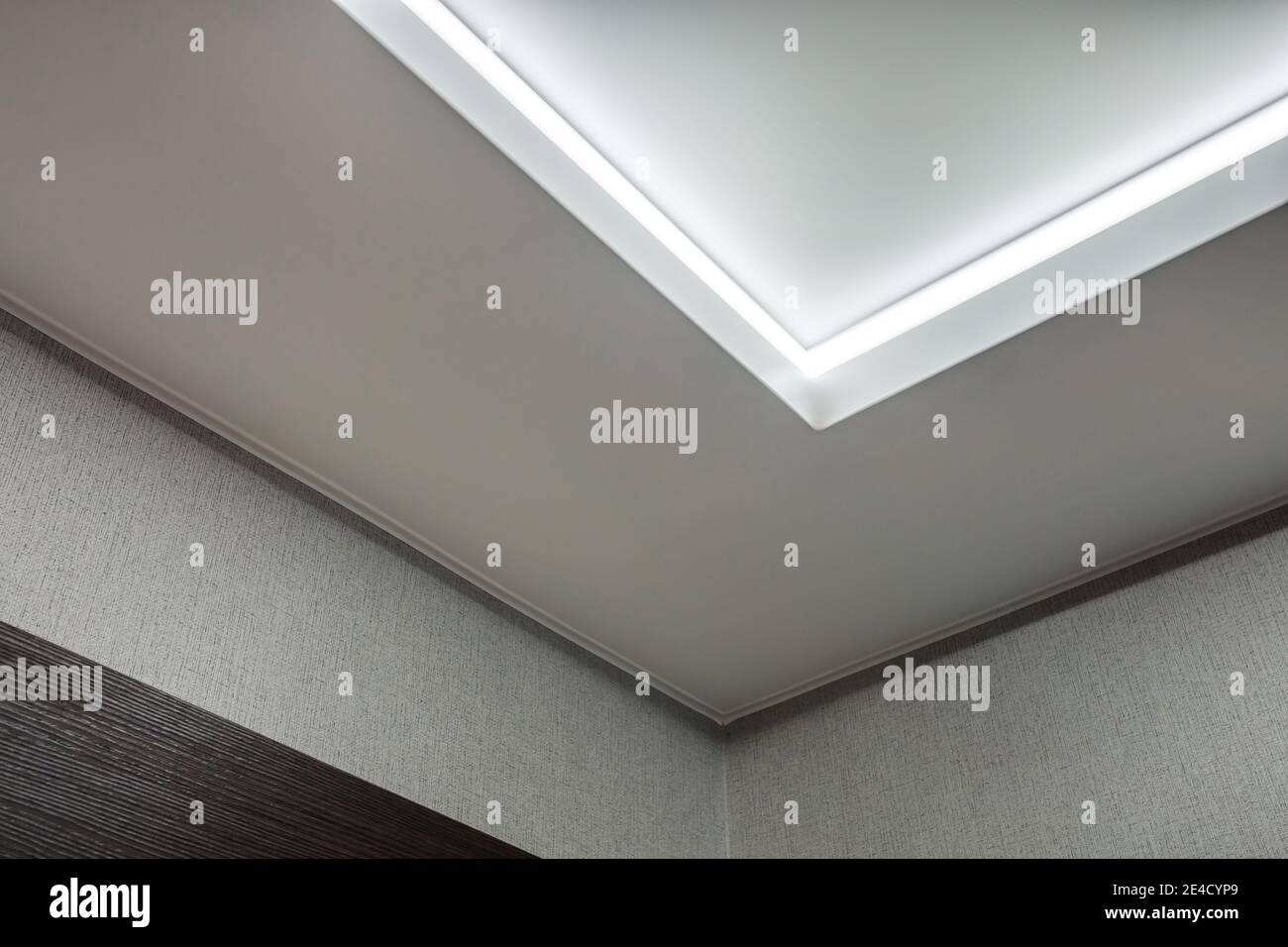 Abgehängte Decke mit Halogenstrahlern und Trockenmauerkonstruktion im leeren Raum in Wohnung oder Haus. Stretchdecke weiß und komplex. Stockfoto