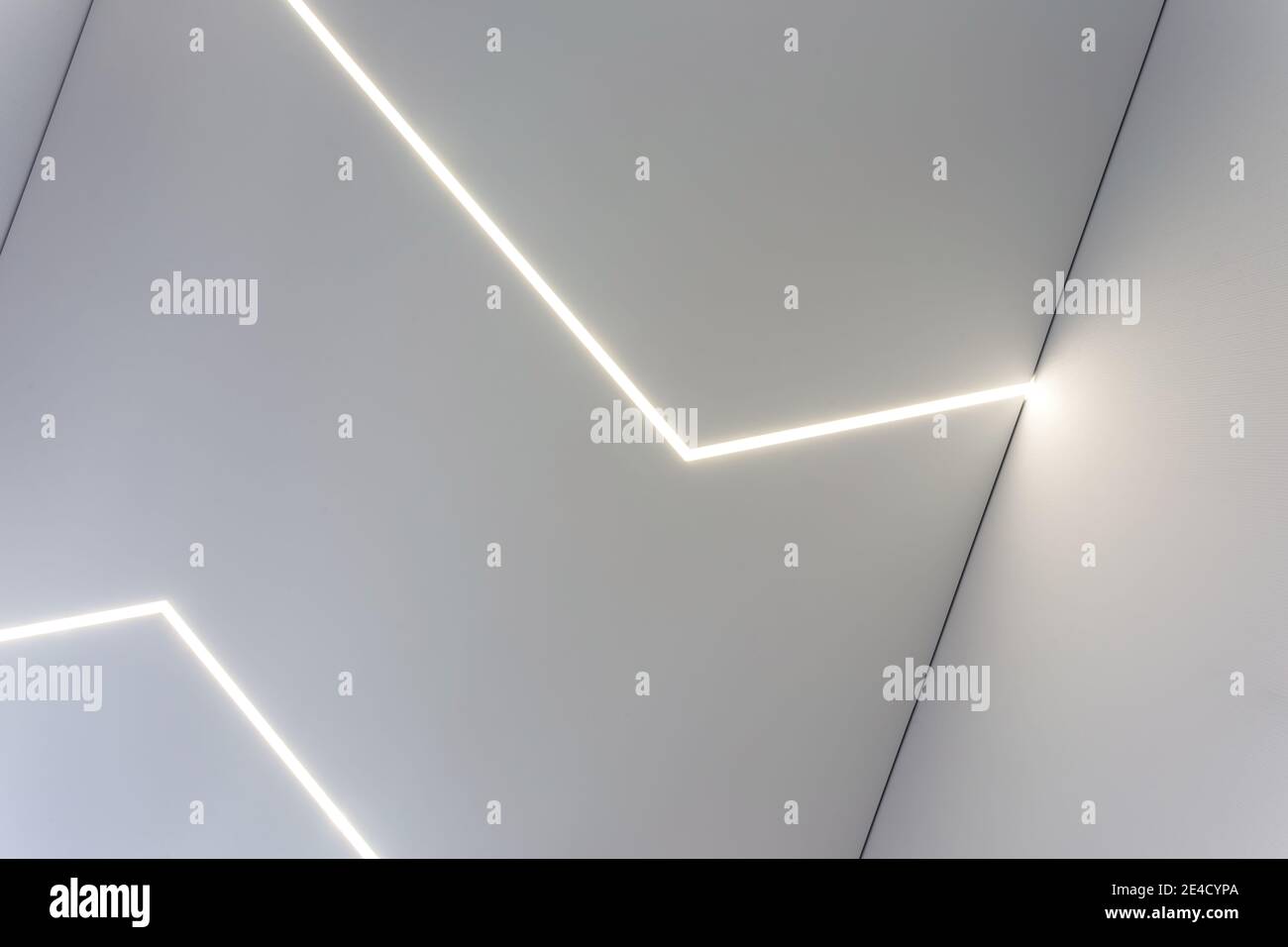 Abgehängte Decke mit Halogenstrahlern und Trockenmauerkonstruktion im leeren Raum in Wohnung oder Haus. Stretchdecke weiß und komplex. Stockfoto