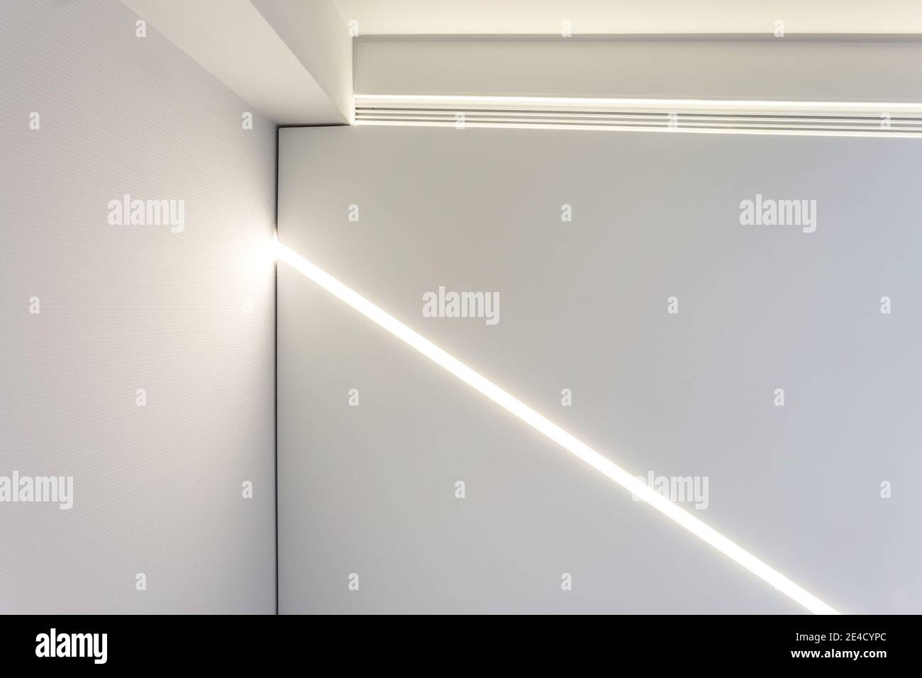 Abgehängte Decke mit Halogenstrahlern und Trockenmauerkonstruktion im leeren Raum in Wohnung oder Haus. Stretchdecke weiß und komplex. Stockfoto