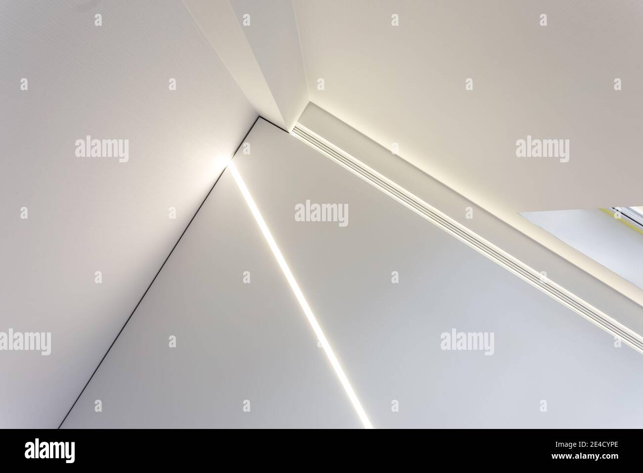 Abgehängte Decke mit Halogenstrahlern und Trockenmauerkonstruktion im leeren Raum in Wohnung oder Haus. Stretchdecke weiß und komplex. Stockfoto
