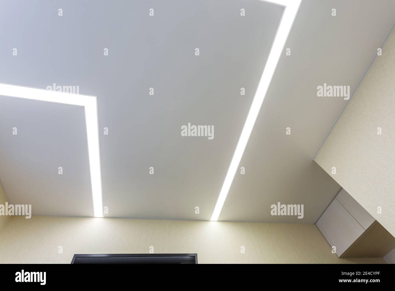 Abgehängte Decke mit Halogenstrahlern und Trockenmauerkonstruktion im leeren Raum in Wohnung oder Haus. Stretchdecke weiß und komplex. Stockfoto