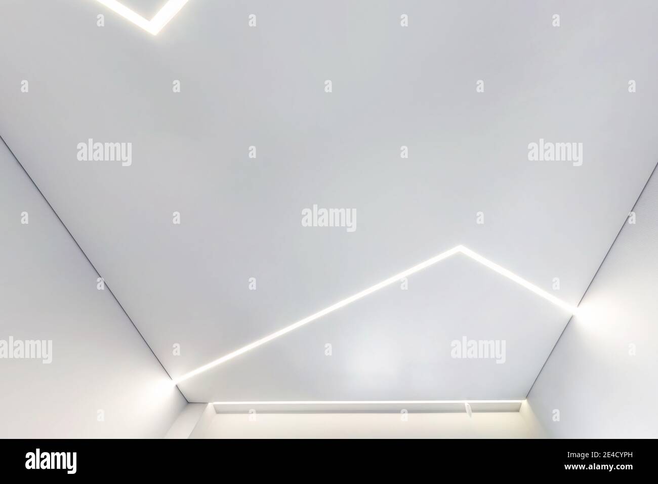 Abgehängte Decke mit Halogenstrahlern und Trockenmauerkonstruktion im leeren Raum in Wohnung oder Haus. Stretchdecke weiß und komplex. Stockfoto