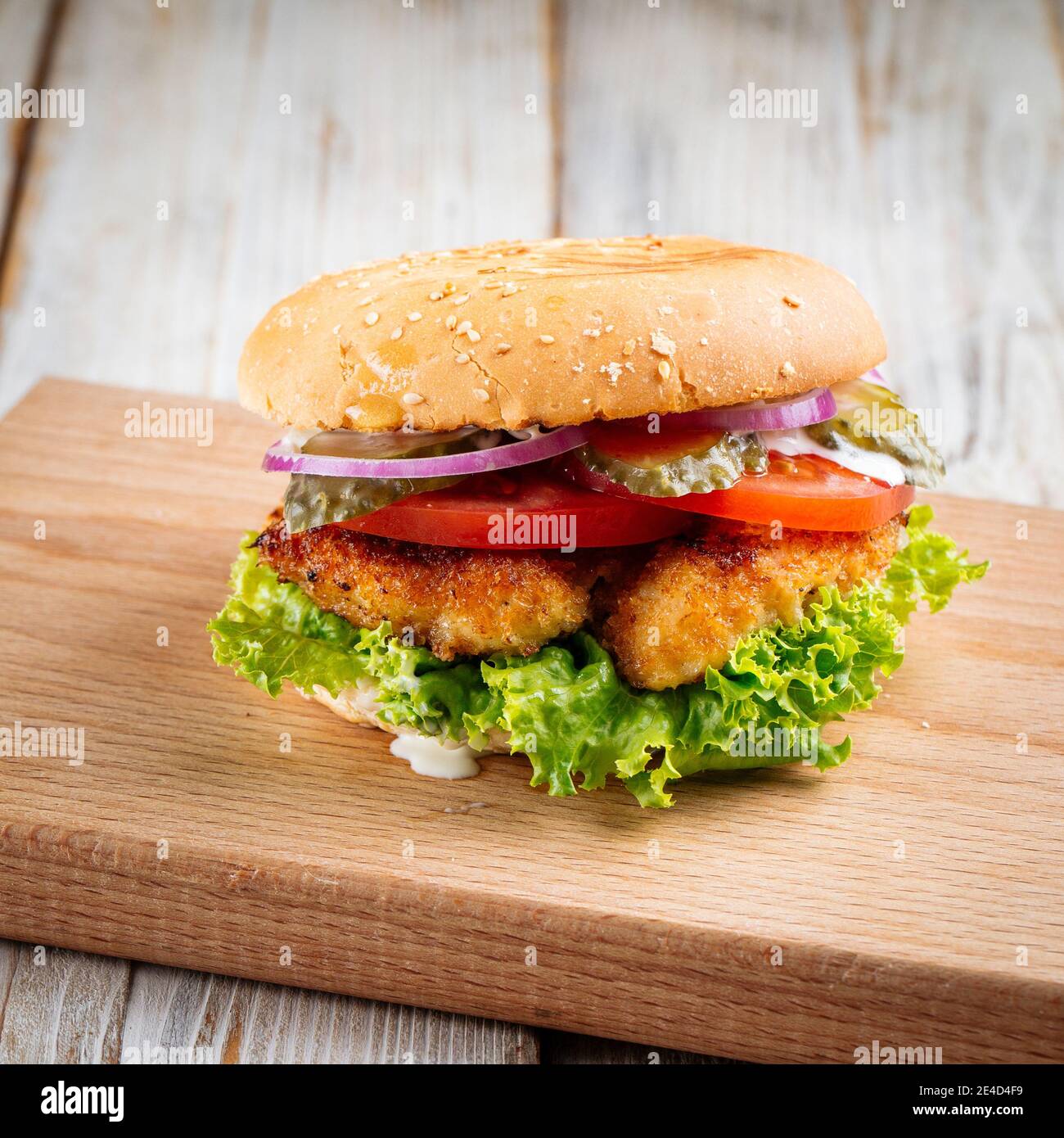 Nahaufnahme auf Zinger Burger mit frittiertem Huhn auf dem Holztisch Stockfoto