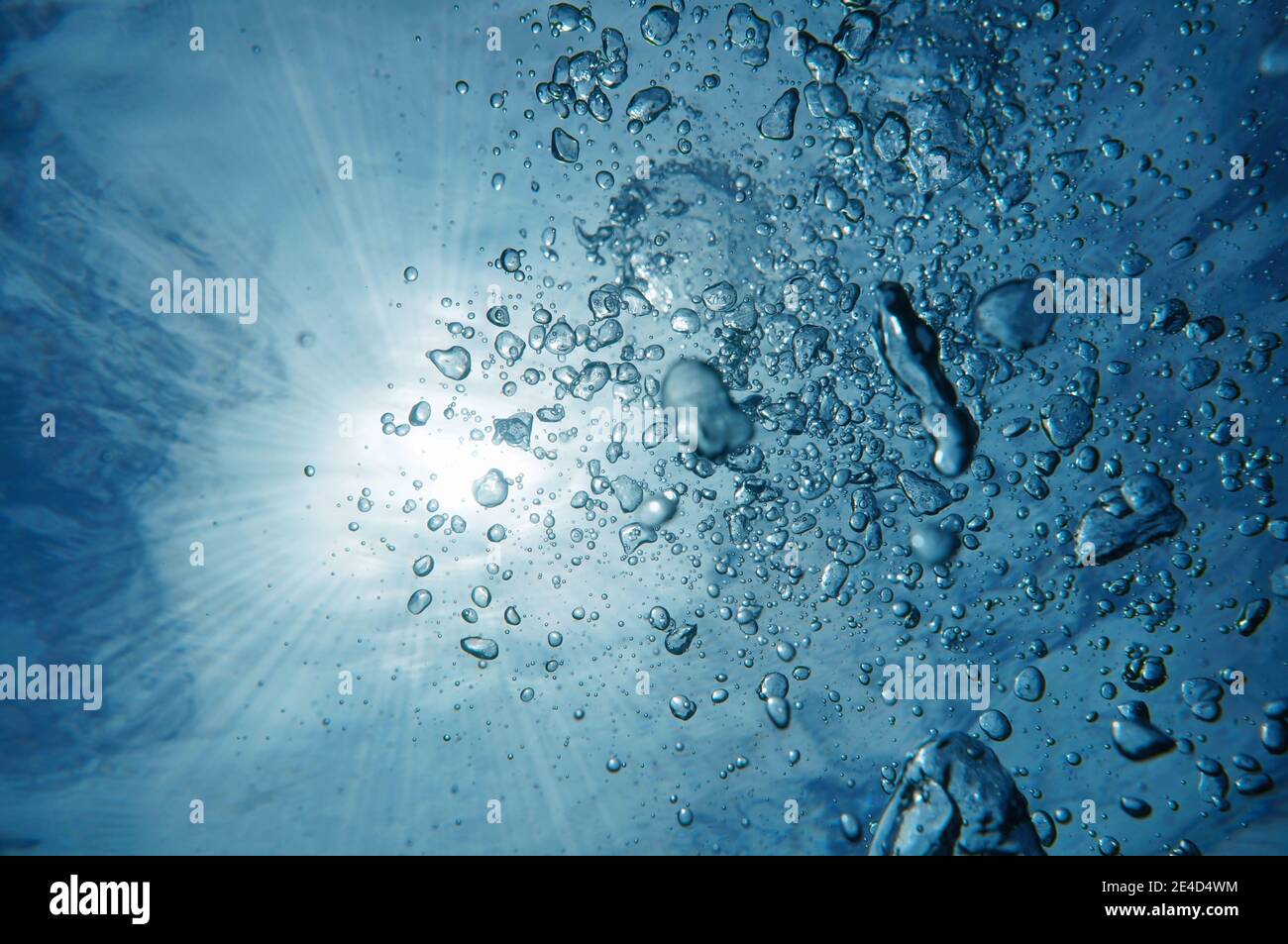 Luftblasen unter Wasser mit Sonnenlicht durch Wasseroberfläche, karibisches Meer Stockfoto