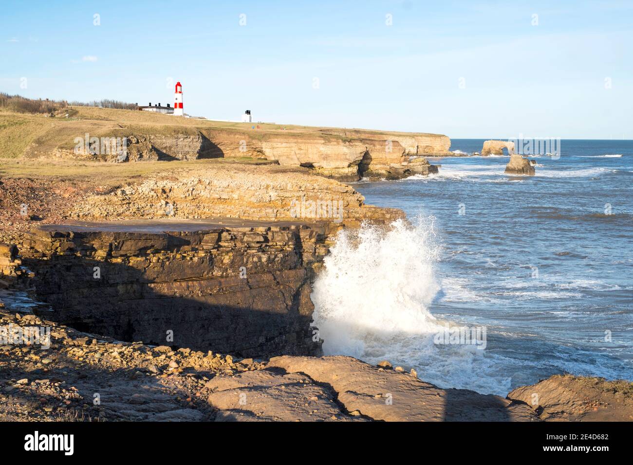 Wellen brechen über Klippen südlich von Souter Point, in Whitburn, Nordostengland, Großbritannien Stockfoto