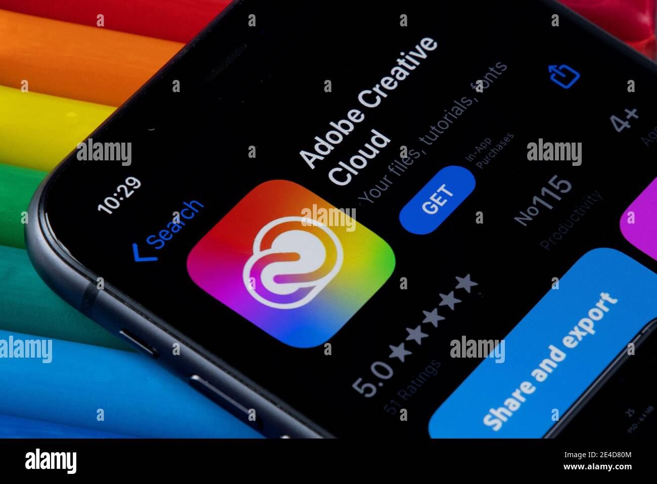 Mobile Adobe Creative Cloud-App im AppStore mit einem bunten Hintergrund aus Plastilin. Installation der Creative Cloud auf dem iPhone. Stockfoto