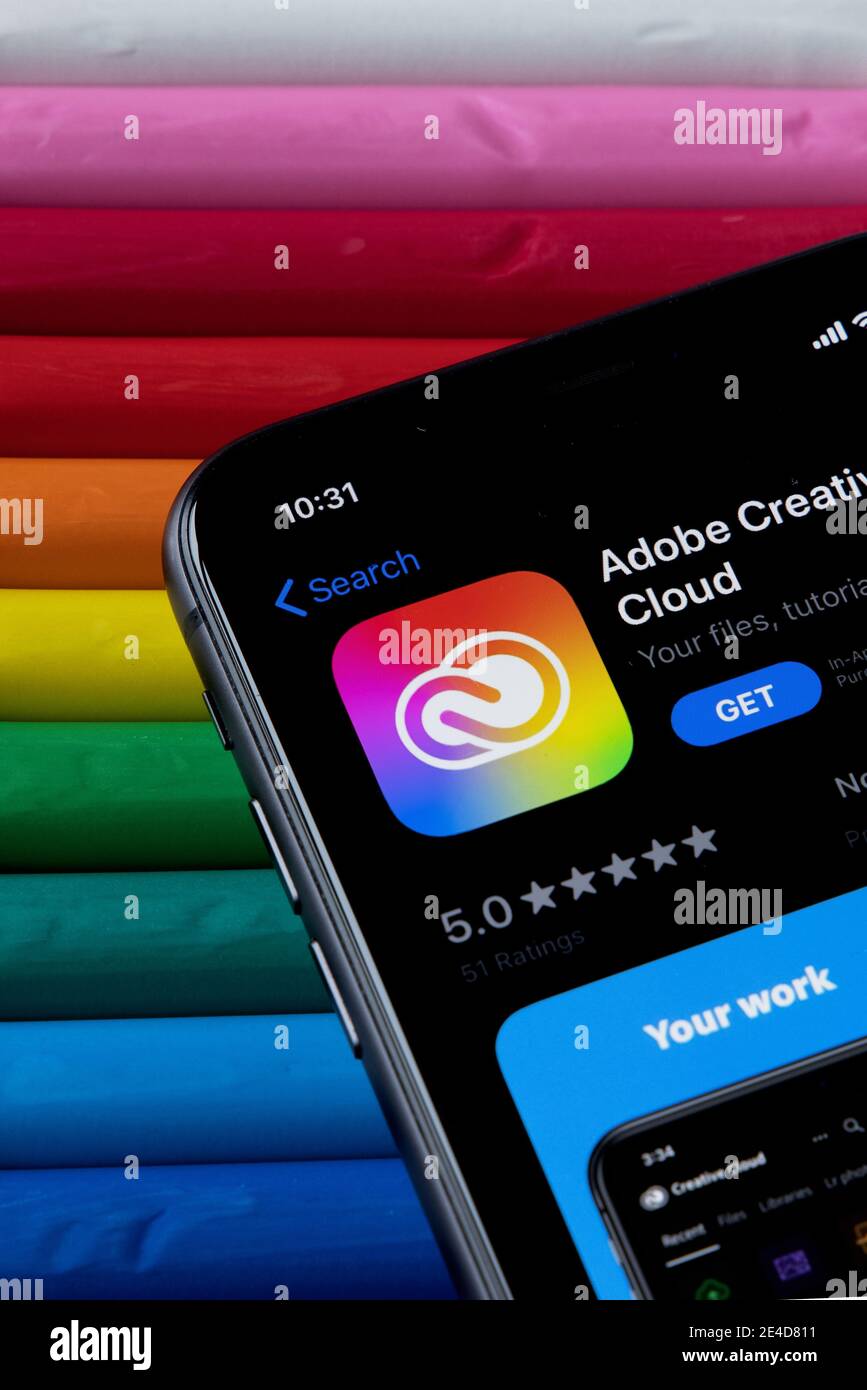 Mobile Adobe Creative Cloud-App im AppStore mit einem bunten Hintergrund aus Plastilin. Installation der Creative Cloud auf dem iPhone. Stockfoto