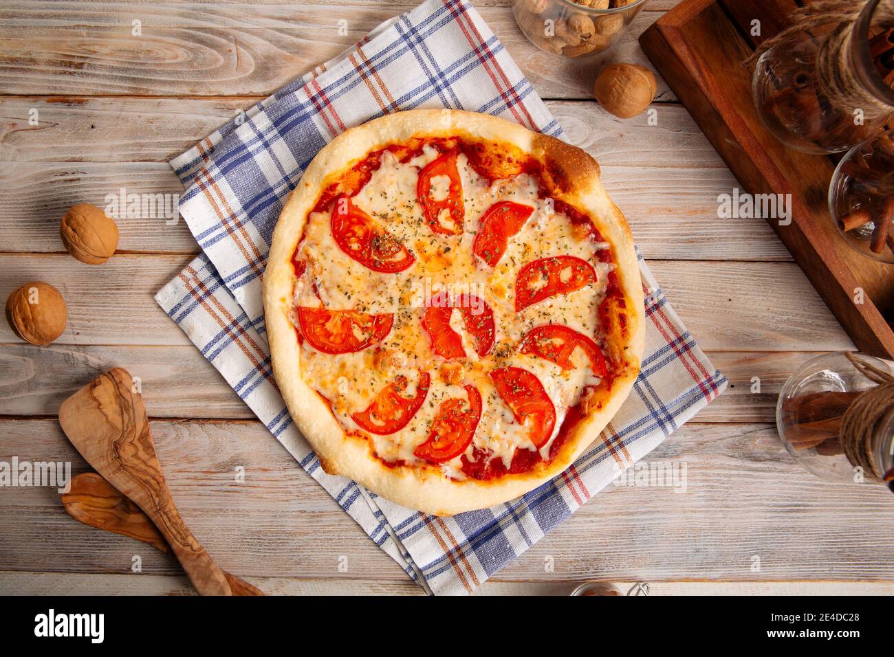 Margherita Pizza mit Tomaten auf dem Holztisch Stockfoto