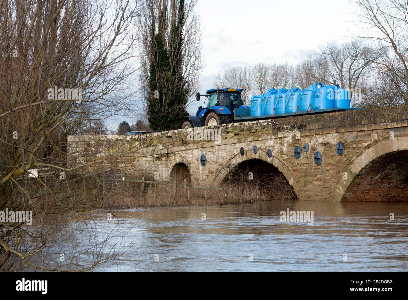 Flutwasser am Fluss Avon an der Barford Bridge mit einer landwirtschaftlichen Traktorüberfahrt, Warwickshire, England, Großbritannien. Januar 2021. Stockfoto