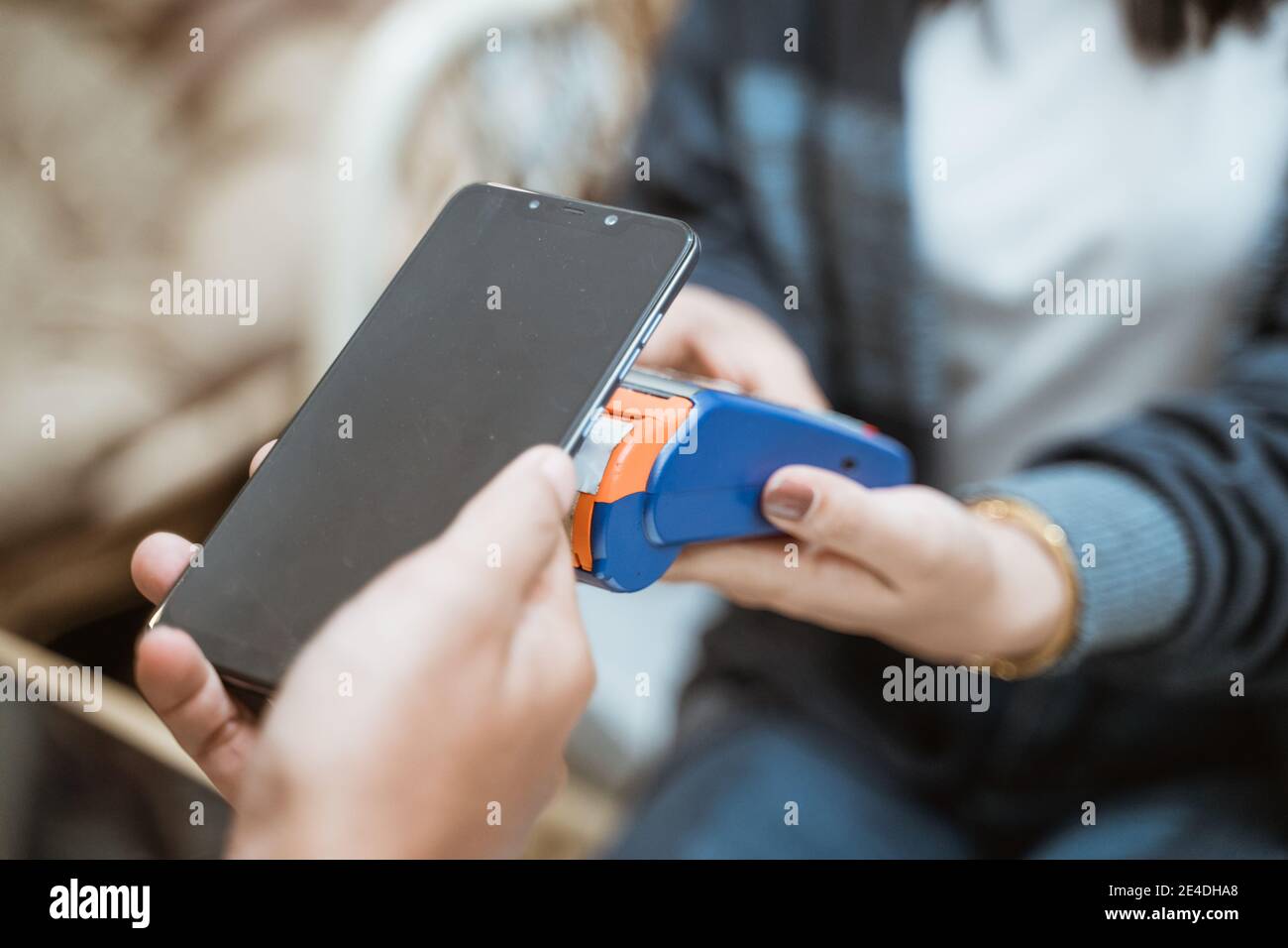 Nahaufnahme des Handtelefons in der Nähe des elektronischen Datenerfassungsgeräts, wenn Einkaufen im Laden Stockfoto