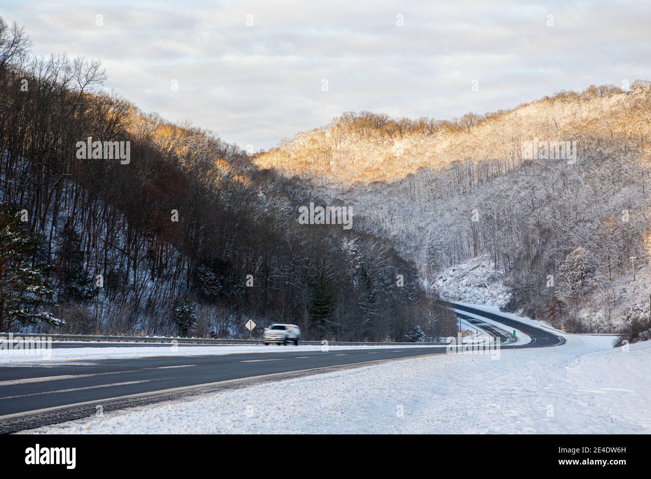 Eine ländliche, bergige Straße schlängelt sich im Winter durch die Appalachen am Fuße des östlichen Kentucky. Stockfoto