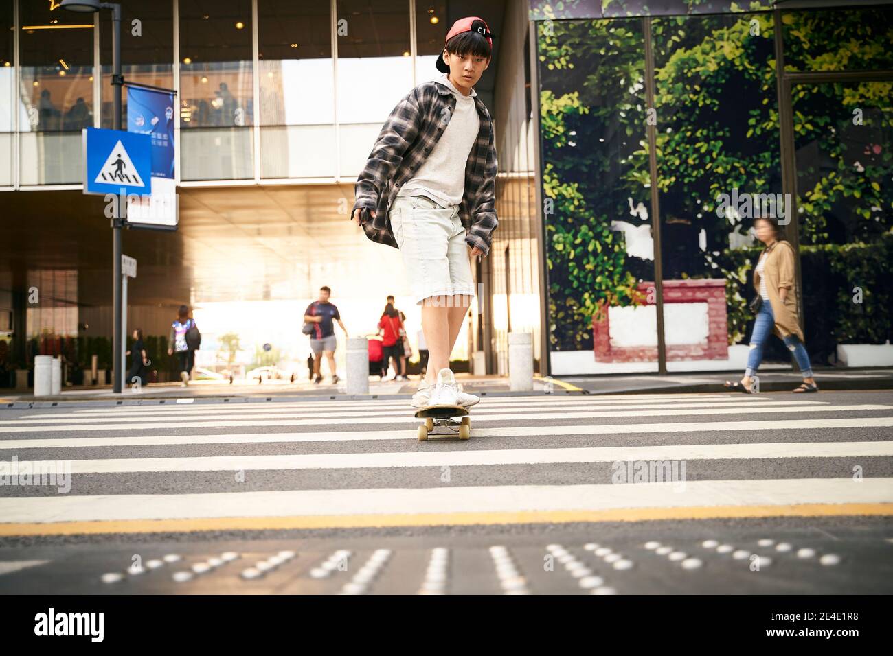 15-jährige asiatische Teenager junge Skateboarding im Freien auf der Straße Stockfoto