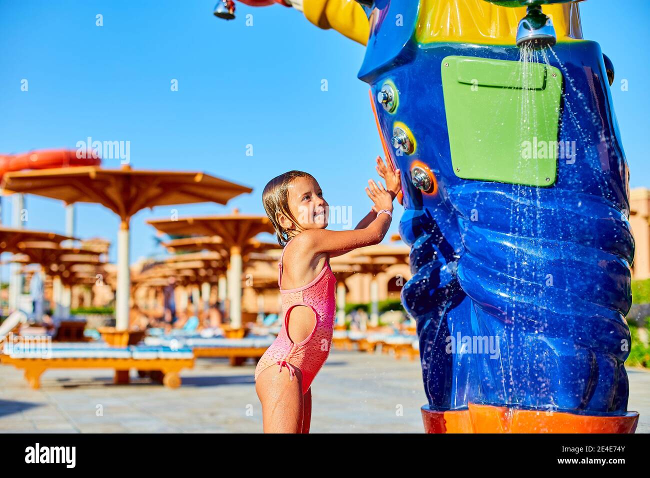 Lustige kleine Mädchen in Badeanzug Kühlung in der Dusche draußen, Kind  spielen mit Wasser im Resort in der Nähe von Schwimmbad, Sommerzeit, Urlaub  Stockfotografie - Alamy