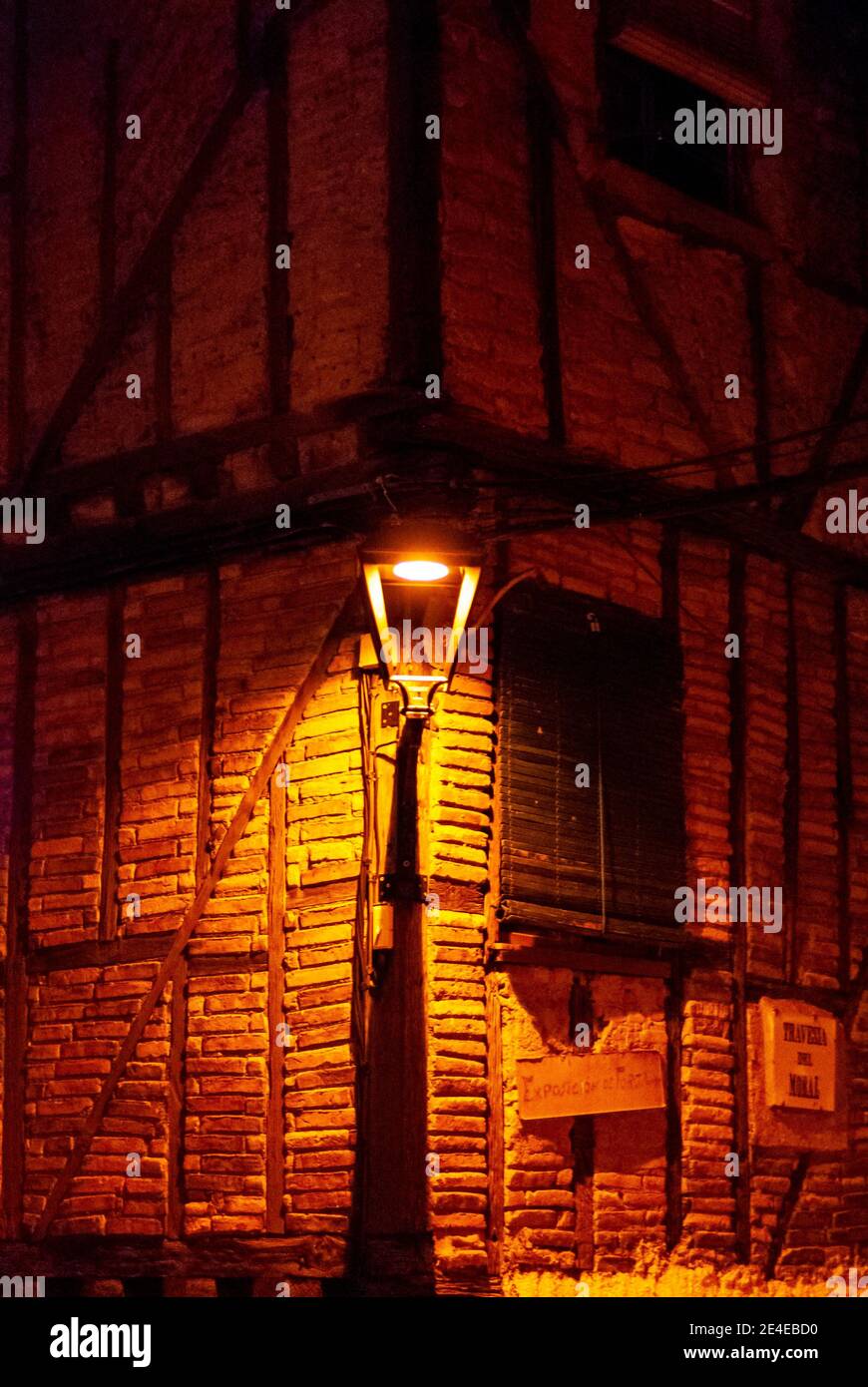 Jüdische Straßenlaterne im jüdischen Viertel Hervas ON Eine Ecke mit adobe-Wand und Holzrahmen in der Nacht Stockfoto